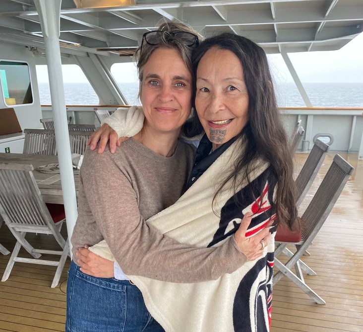Two women embracing on a ship's deck.