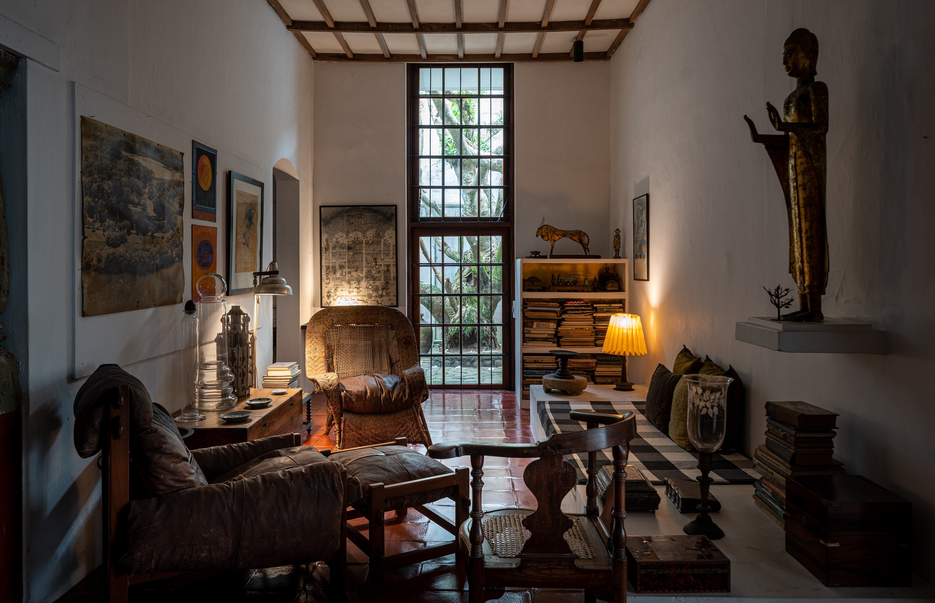 Interior of a room with furniture, artwork, and a Buddha statue.