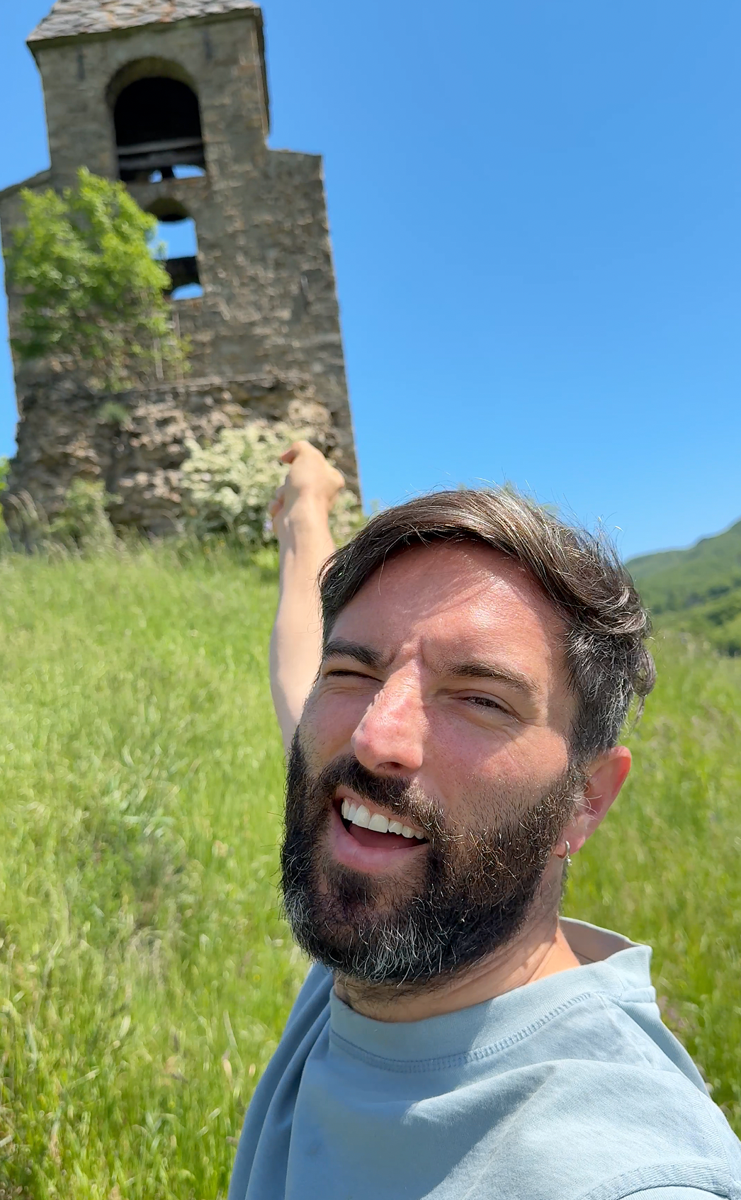 Man pointing at a stone tower.