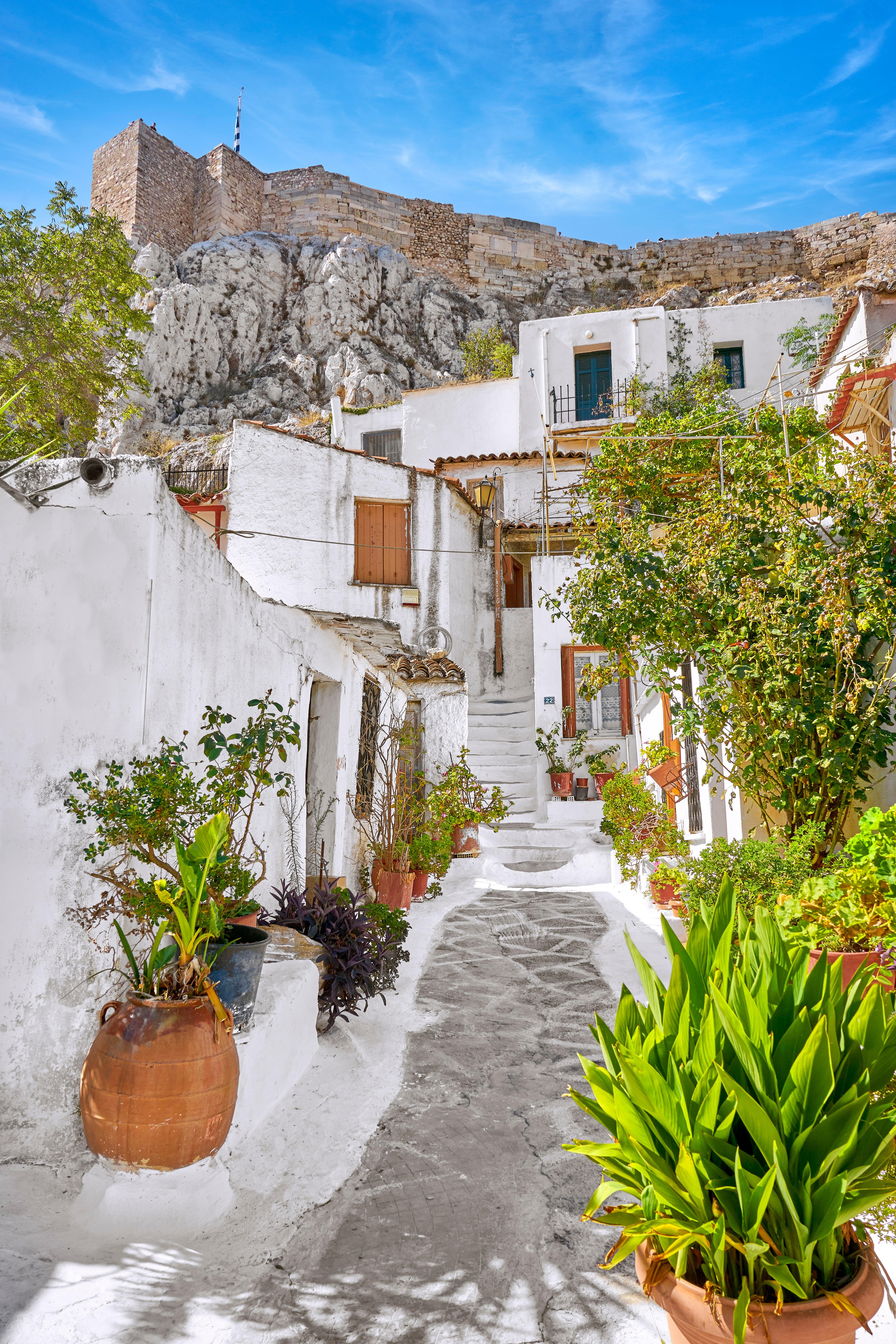 Whitewashed houses in the Anafiotika neighborhood of Plaka, Athens, with the Acropolis in the background.
