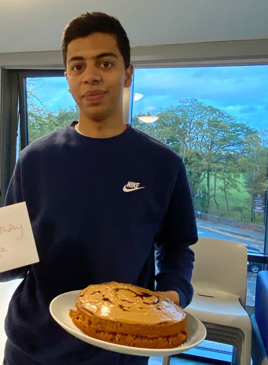 Omar holding a birthday cake at Liverpool University on his 20th birthday.